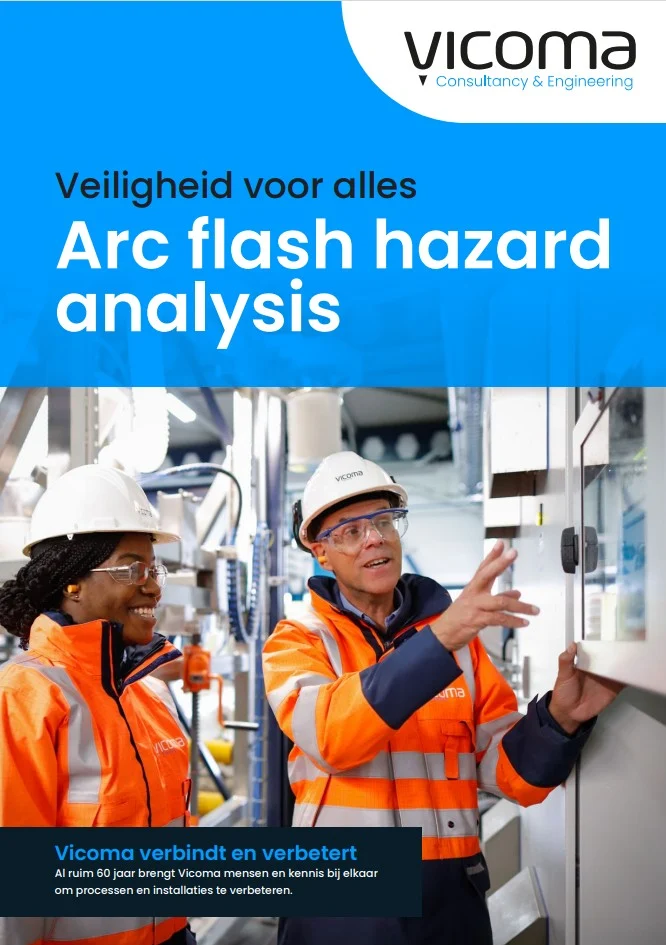 Two engineers in safety gear conduct an arc flash hazard analysis in an industrial setting.