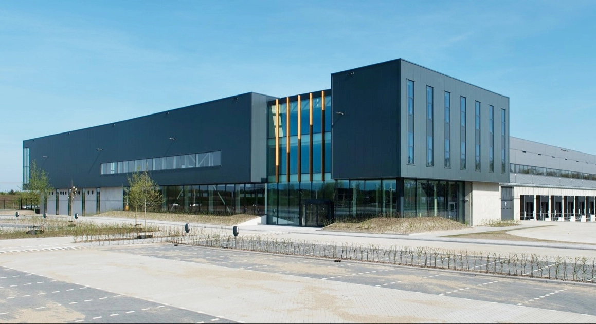 Modern industrial building with large glass windows, part of Logistics Excellence in Tilburg.