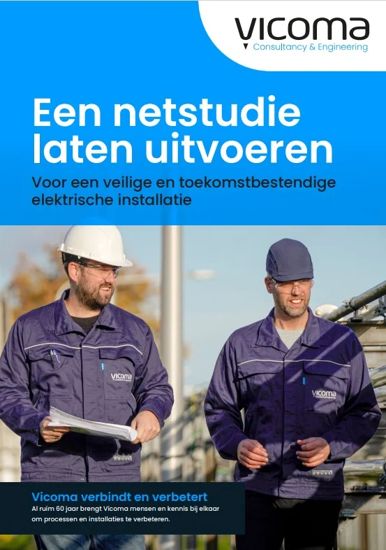 Two men in work uniforms and helmets walking outdoors near industrial equipment.