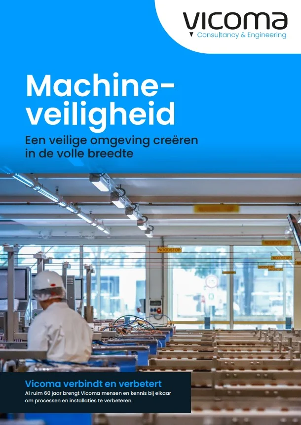 Worker in a factory setting focused on machine safety under fluorescent lighting.