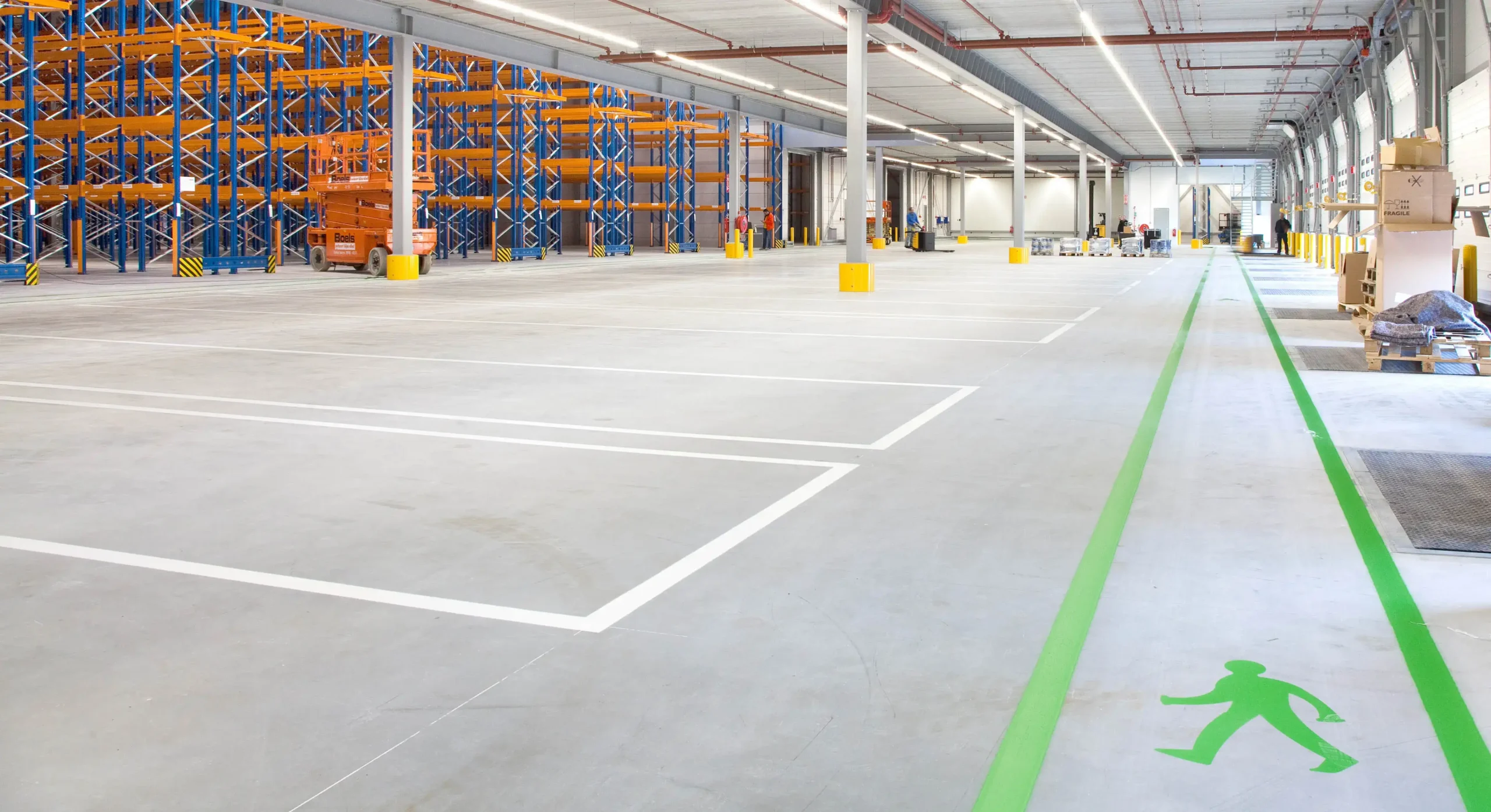 Interior of a spacious warehouse with storage racks and designated walking lanes.